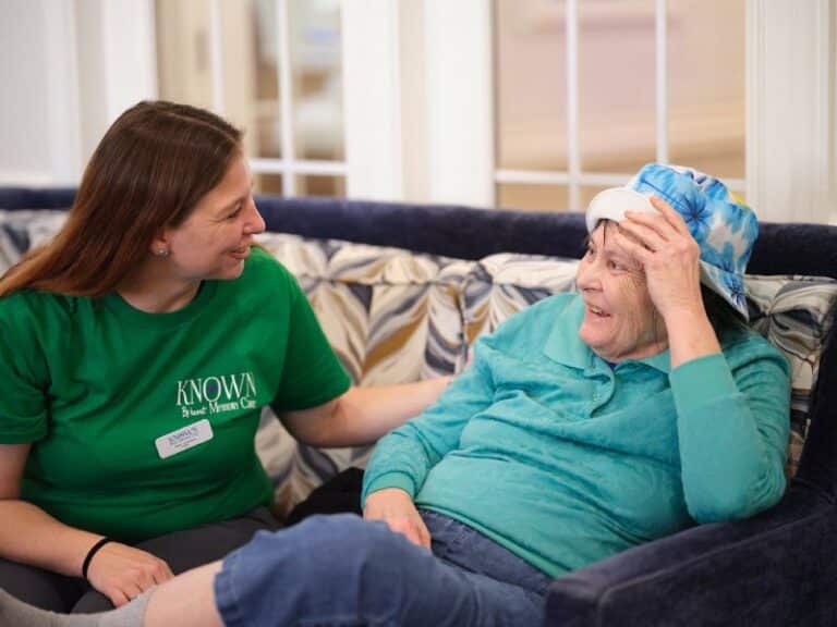 Known Memory Care | Resident with caregiver on couch