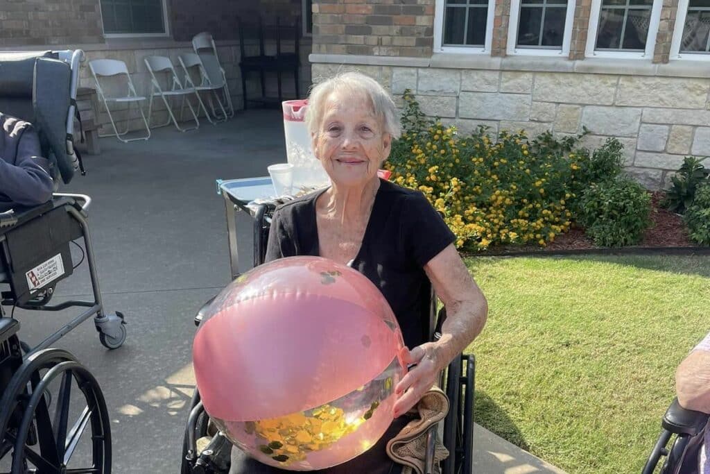 Known Memory Care | Senior resident holding a beach ball